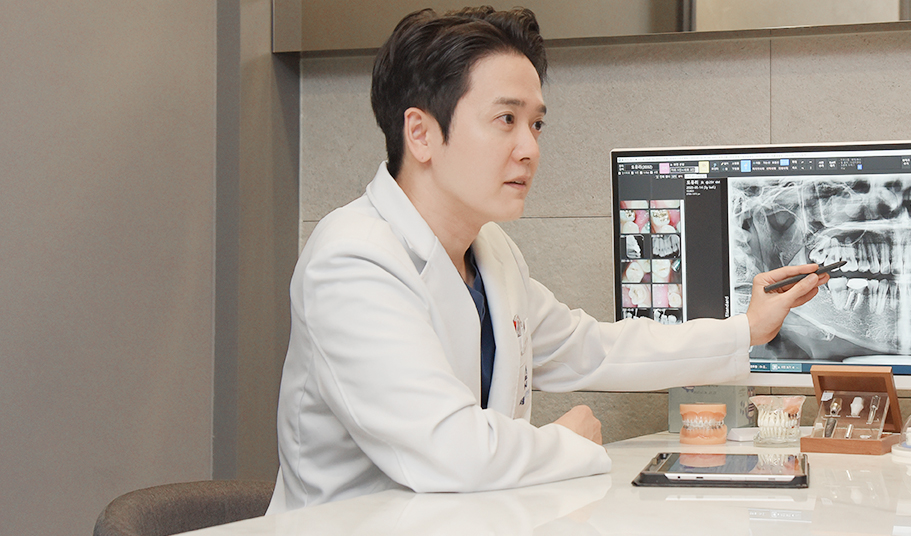 엑스레이를 보며 임플란트 견적 구성을 설명하는 서울더자연치과 원장